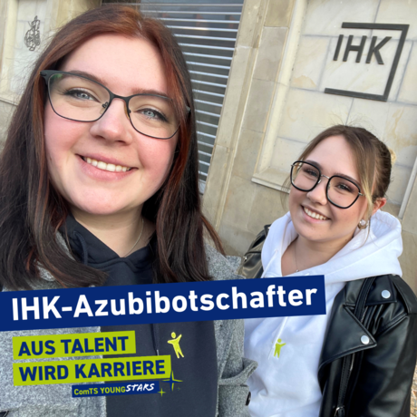 Zwei junge Auszubildende stehen vor der Fassade der IHK in Magdeburg.